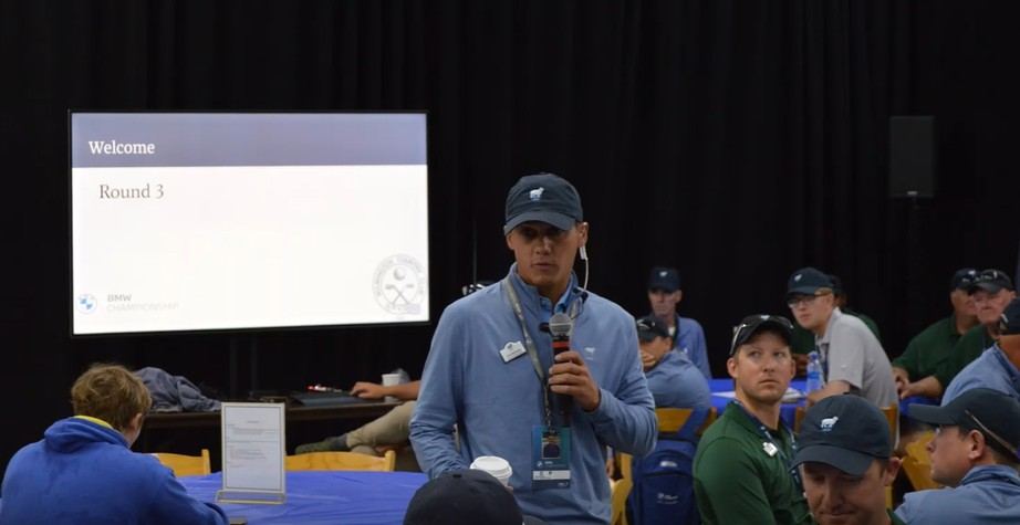 Tom speaking to the crew in front of a Welcome, Round 3 slide