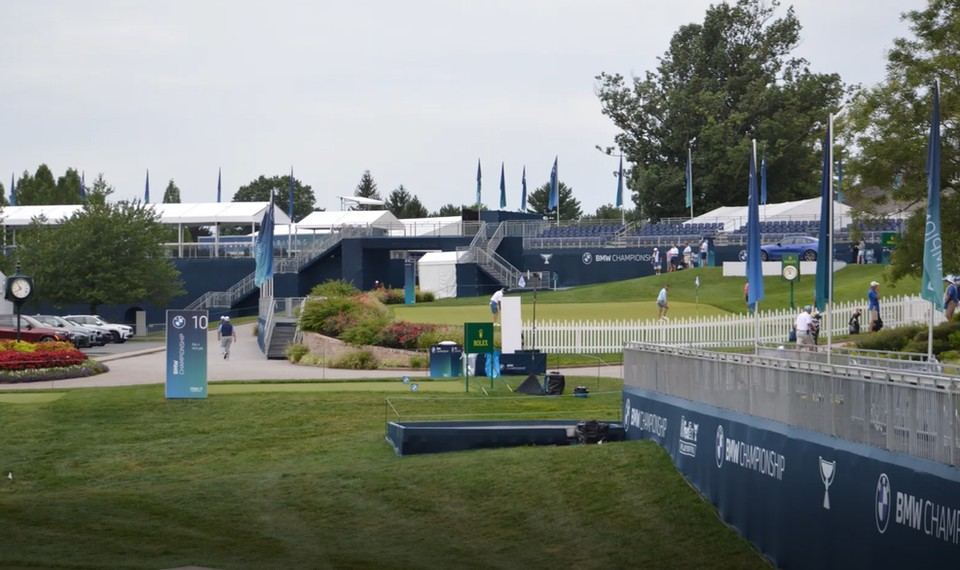 Crew hand-watering a fairway at dawn ahead of tournament play
