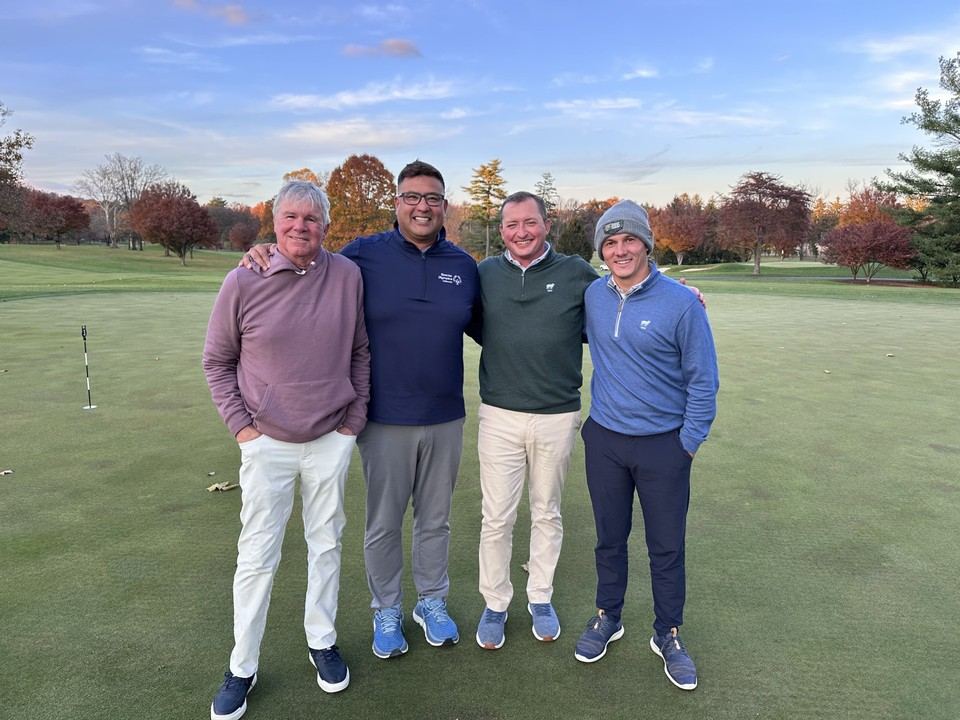 Tom with three peers on a putting green at a superintendent/pro golf outing